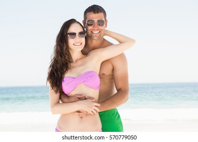 Smiling Couple Hugging On The Beach On A Sunny Day