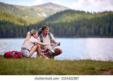 Smiling Couple  looking at a travel map.adventure on mountain  - Powered by Shutterstock