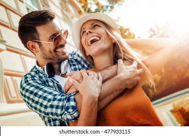 Smiling couple in love outdoors.Young happy couple hugging on the city street. - Powered by Shutterstock