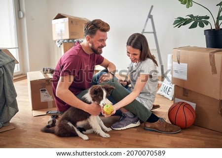 Smiling couple in new home with their dog
