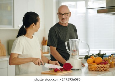 Smiling Couple Preparing Smoothie in Modern Kitchen - Powered by Shutterstock