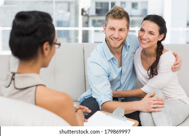 Smiling Couple Reconciling At Therapy Session In Therapists Office