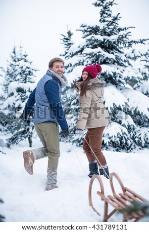 Smiling couple with a sled