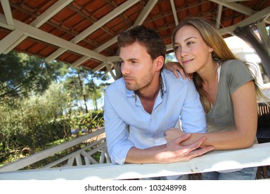 Smiling Couple Standing In Private Home Gazebo