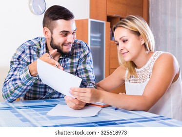 Smiling Couple At The Table  Filling Forms For Joint Banking Account
