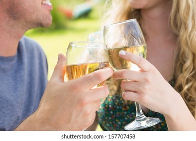 Smiling Couple Toasting With White Wine Outside On Sunny Day