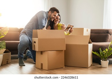 Smiling couple unpacking boxes in new home.New life. - Powered by Shutterstock