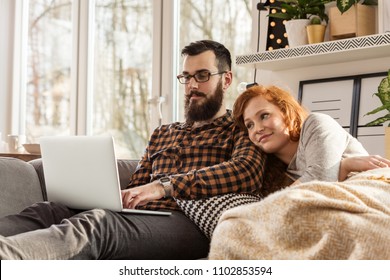 Smiling Couple Watching A Movie On Laptop. Happy Wife And Husband During Date Night