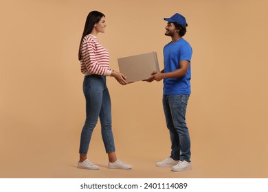 Smiling courier giving parcel to receiver on light brown background - Powered by Shutterstock