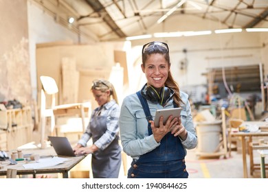 Smiling Craftsman Woman In Carpentry Workshop Using Tablet Computer