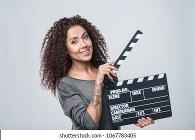 Smiling Curly Female Holding Movie Clapper Board, Slate Film.