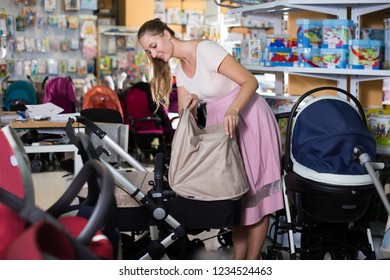 Smiling  Customer Buying Pram For Newborn In Infant Shop