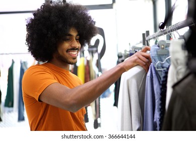 Smiling Customer Looking For Clothes To Buy In Store