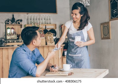 Smiling Customer Paying By Cash At The Coffee Shop