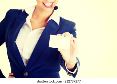 Smiling Customer Service Representative With Headset Holding A Blank Empty Businesscard. Isolated On White Background.