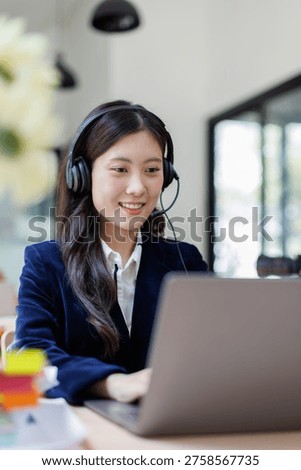 Smiling Customer Support Agent Wearing Headset Working on Laptop in Office
