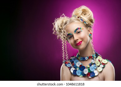 Smiling cute face nice blonde child girl wearing DIY bijou accessories made multi  colored buttons  Funny make  up   pasted buttons her eyebrows  Pink  dark gradient background  Copy space 
