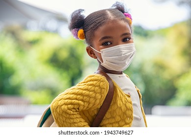 Smiling Cute Little Girl With School Backpack And Protective Face Mask Ready For First Day Of School During Covid Pandemic. Black Kid Going Back To School During Coronavirus Pandemic Disease. 