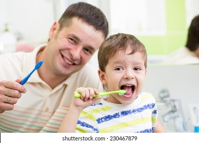 Smiling Dad And Kid Son Brushing Teeth In Bathroom