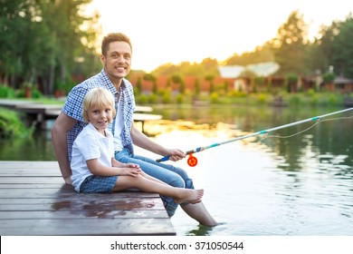 Smiling Dad And Son Fishing Outdoors