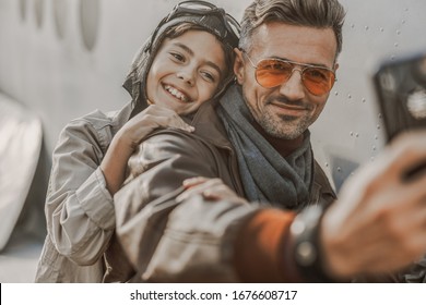 Smiling Dad In Sunglasses Taking Photo With His Son While Using Mobile Phone Stock Photo