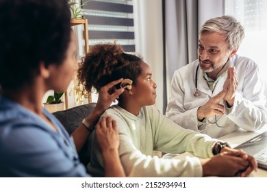 Smiling Deaf African American Girl With Ear Implant At Doctor's Office.