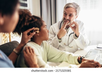 Smiling Deaf African American Girl With Ear Implant At Doctor's Office.