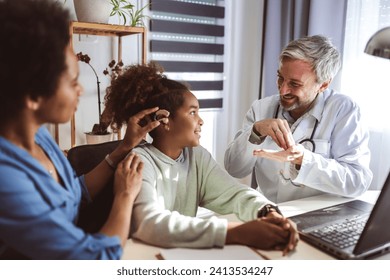 Smiling deaf african american girl with ear implant at doctor's office. - Powered by Shutterstock