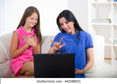 Smiling Deaf Woman And Child Talking Using Sign Language On The Laptop