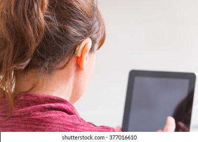 Smiling Deaf woman using tablet at home