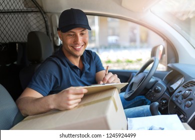 Smiling delivery man sitting with boxes in his van - Powered by Shutterstock