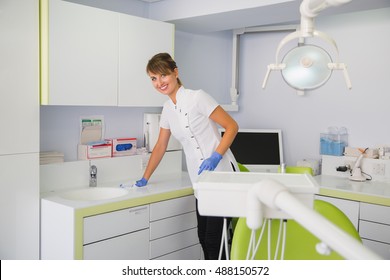 Smiling Dentist Cleaning Up Her Worrkplace After Hard Working Day.