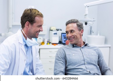 Smiling Dentist And Patient Interacting With Each Other In Dental Clinic