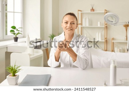 Smiling dermatologist, also skilled as a cosmetologist and beautician, poses for a portrait in beauty salon office. Portrait captures the essence woman in clinic and doctor professionalism.