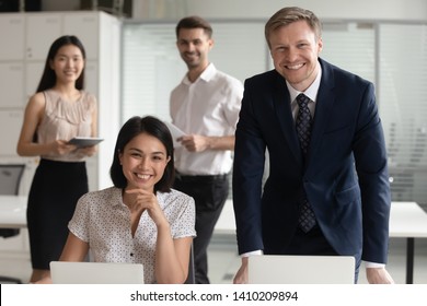 Smiling Diverse Business Leaders Managers Posing With Computers And Team People In Office, Multicultural Enterprise Workforce Professionals Looking At Camera, Corporate Employees Group Staff Portrait