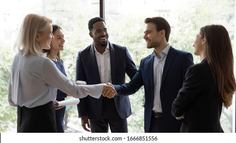 Smiling diverse businesspeople shake hands greeting getting acquainted at office meeting, happy colleagues employees handshake closing deal or making agreement after successful negotiations - Shutterstock ID 1666851556