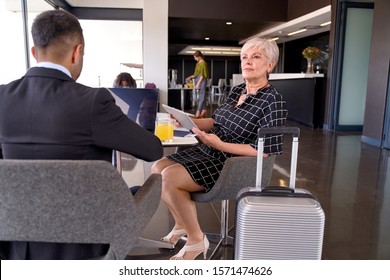 Smiling diverse colleagues sitting in modern airport lounge with - Powered by Shutterstock