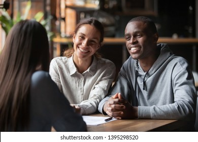 Smiling Diverse Couple Listening To Financial Advisor Or Realtor At Meeting In Cafe, African American Husband And Wife Taking Loan Or Mortgage, Successful Negotiations With Lawyer Or Insurance Broker