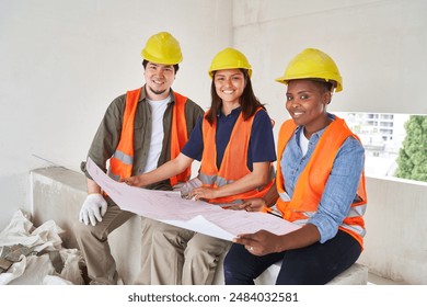 Smiling diverse coworkers analyzing blueprint - Powered by Shutterstock