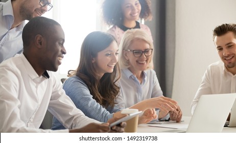 Smiling Diverse Employees Listening To Businesswoman Coach At Briefing, Mentor Explaining Strategy, Training Staff, Using Laptop, Helping With Software, Team Building Activity, Horizontal Photo