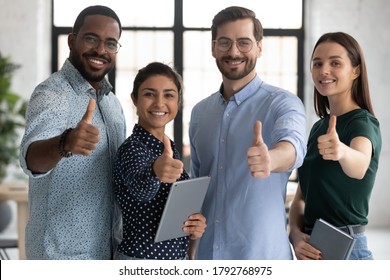 Smiling diverse employees team showing thumbs up, looking at camera, happy overjoyed colleagues recommending best corporate service, good career, human resources and employment concept - Powered by Shutterstock