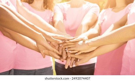 Smiling Diverse Women Wearing Breast Cancer Pink Ribbon T-Shirts Holding Hands Outdoor In Park. Selective Focus, Cropped - Powered by Shutterstock