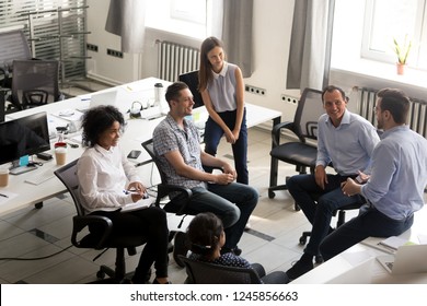 Smiling Diversity Team Of Employees, Interns Sitting Circle, Listening To Business Coach On Training, Trainer, Discussing Business Strategy, Plan With Male Leader, Involved In Team Building Activity