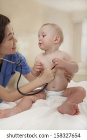 Smiling Doctor Checking A Baby's Heart Beat With A Stethoscope