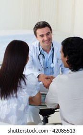 Smiling Doctor Explaining Diagnosis To A Couple During A Visit