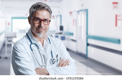 Smiling doctor in glasses on hospital corridor, Trustworthy older man with gray hair.