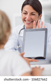 Smiling Doctor Showing A Tablet Computer To A Child In Hospital Ward, Healthcare Workers In The Coronavirus Covid19 Pandemic