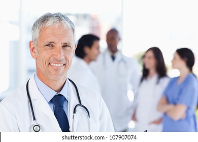 Smiling Doctor Waiting For His Team While Standing Upright