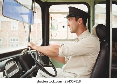 Smiling Driver Driving The School Bus Outside The Elementary School