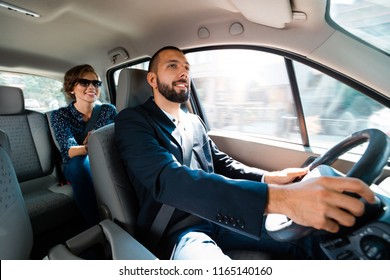 Smiling driver talking with elegant businesswoman.